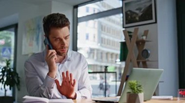 Şirketin CEO 'su cep telefonuyla şikâyet ediyor modern şirket ofislerini kapatıyor. Sinirli iş adamı akıllı telefonu arıyor ve anlaşmazlık yaşıyor. Stresli yönetici telefon konuşmasında bağlantı sorunu tartışıyor.