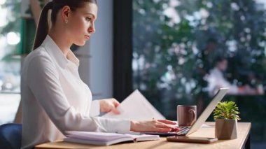 Şirket uzmanı modern ofis alanlarını kapatmaya odaklanmış. Akıllı bayan yönetici dizüstü bilgisayarda iş planı yapıyor. Profesyonel kadın çalışan, belgeleri analiz etmekle meşgul..