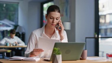 Ofisin açık alanındaki iş belgelerini elinde tutan memnuniyetsiz bir yönetici kavgası. Sinirli iş kadını telefon üzerine rapor hatasını tartışıyor. Endişeli bayan akıllı telefon konuşmasını bitirdi