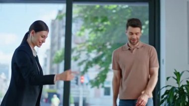 Dost canlısı iş kadını, müşteriyle modern ofiste görüşüyor. İki iş ortağı şirket masasında el sıkışıyor. Gülümseyen kadın danışman sakallı yatırımcıya anlaşma gösteriyor..