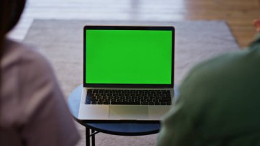 Kimliği belirsiz bir çift kahve masasında oturmuş yeşil ekran dizüstü bilgisayar izliyor. Arka plan tanımlanamayan çift görünümlü kroma anahtar bilgisayar ekranı evde sohbet eden çevrimiçi konuşma video çağrısı 