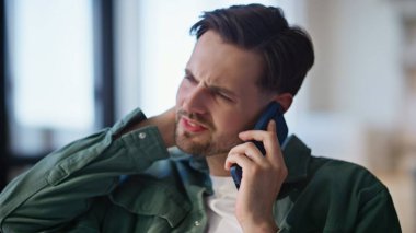 Sinirli adam cep telefonunu arıyor ve evde dinleniyor. Tıraşsız, akıllı telefondan konuşan bir adam oturma odasında oturuyor. Cep telefonuyla konuşan yorgun hippi kafası. İletişim konsepti