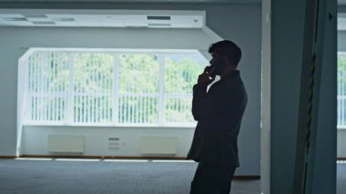 İş adamı silueti konuşuyor. Akıllı telefon ofis otoparkını kapatıyor. Duygusal patron, cep telefonu konuşmasında partnerini arıyor. Kızgın yönetici binaya cep telefonu çağrısı yapıyor.