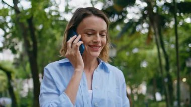 Yakın plan aşığı akıllı telefon yeşili doğayla flört ediyor. Portre çekici yetişkin kadın cep telefonundan arıyor yemyeşil bahçe yerinde duruyor. Parkta cep telefonu görüşmesini yalnız bitiren mutlu güzel bayan. 