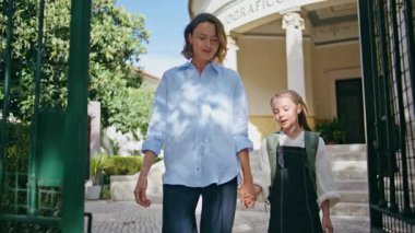 Anne çocuk okul bahçesinde geziniyor. Sunny Street 'te bir kadınla yürüyen tatlı bir kız öğrenci. Anne babasıyla konuştuktan sonra sırt çantalı küçük çocuk sakince gidiyor. Küçük kız annesinin elini tutuyor.