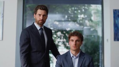 İş yerindeki iş yerindeki iş arkadaşları kameraya gülümsüyor. Modern kabineye poz veren iki pozitif ortak uzaklaşır. Neşeli meslektaşlar parmakla işaret ediyor. Başarılı insanlar konsepti 