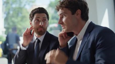 Çağrı ortakları modern ofiste birlikte başarılı bir anlaşmaya seviniyorlar. Akıllı telefondan konuşan duygusal adam el sıkışırken heyecanlanıyor. Mutlu meslektaşlar cep telefonundan harika haberler alıyor.