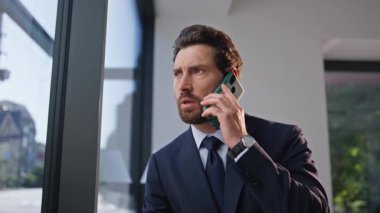 Endişeli CEO konuşan cep telefonu rahat kafeterya masasında tek başına zum yapıyor. Ciddi bir iş adamı kahve molasında cep telefonuyla iş görüşmesi yapıyor. Takım elbiseli endişeli bir kafe ziyaretçisi duygusal konuşuyor.