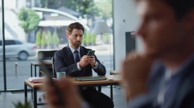 Şirket ofisinde akıllı telefonlara mesaj atan ciddi iş arkadaşları var. Rahat iş arkadaşı, birlikte çalışan bir resme cep telefonuyla mesaj atıyor. İş yerinde cep telefonu yazan resmi takım elbise yöneticisi