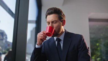 Zengin CEO kahve içiyor panoramik kafe dinleniyor şehir manzarasına bakıyor. Kendine güvenen sakallı işadamı işe ara veriyor.