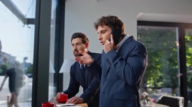 Erkek patron, şehir merkezinde iş ortağıyla cep telefonunu tartışıyor. İki şirket çalışanı duygusal tepki vermekte zorlanıyor. Çılgın iş adamları el kol hareketi yapıyor, gergin hissediyorlar.