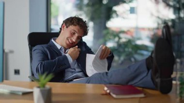 İdari belgeler okunuyor masa kapanırken ofis oturuluyor. Profesyonel iş adamı iş belgelerini tartışırken cep telefonuyla konuşuyor. Belgelerle gülümseyen girişimci