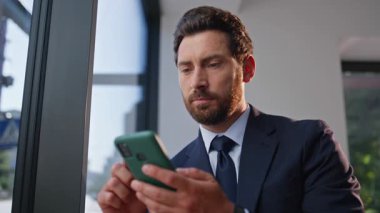 Cep telefonu kullanan zarif bir çalışan panoramik odayı kapatıyor. Keyifli, kendinden emin iş adamı rahat bir otel lobisinde akıllı telefon mesajı veriyor. Olumlu, mutlu adam, modern kafeyi tek başına rahatlatıyor.