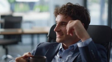 Gülümseyen işçi panoramik dolap portresinde dinlenirken kahve içiyor. Elinde çay fincanı olan yakın plan bir adam ofiste mola veriyor. Mutlu sakin yönetici içeceğini yudumluyor. İş adamı patron kendini rahat hissediyor.