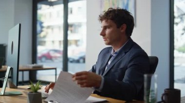 Bilgisayar işyerindeki ciddi CEO kontrol raporları yakın planda. Akıllı profesyonel muhasebeci finansal analizde çalışan belgelere odaklanmış. Genç işadamı istatistik arama belgeleri geliştiriyor