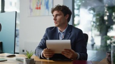 İş adamı elinde kağıtlarla web kamerası laptopuyla konuşuyor açık alanda internetten görüşme yapıyor. Gülümseyen menajer iş anlaşmasını video görüşmesiyle tartışıyor. Mutlu çalışan belgeyi uzaktan sunuyor