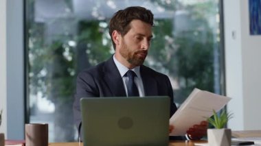 Ofis işyerinde çalışan sakallı girişimci evraklarını yakından inceleyin. Neşeli iş adamı sözleşmeyi okurken tatmin oluyor. Yakışıklı yönetici iş planları pazarlama stratejisi üzerinde kafa yoruyor 