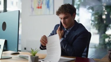 Ofiste cep telefonundan konuşan birden fazla iş adamı yakın çekimde belgeleri okuyor. Yönetici, bilgisayar işyerinde çalışan ortakları arıyor. Profesyonel danışman akıllı telefon görünümlü kağıtları konuşuyor.