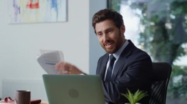 İş koçu ışık ofisinden görüntülü konuşmayı arıyor. Neşeli iş adamı ortağıyla sanal görüşme yapıyor. Gülümseyen orta yaşlı yönetici panoramik iş yerinde online konuşma dizüstü bilgisayarına danışmanlık yapıyor