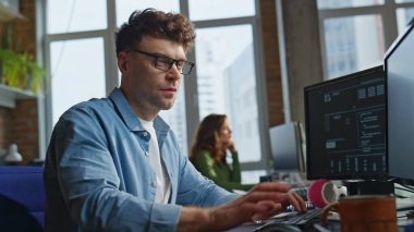 İş yerinde klavye yazma kodu yazan gözlüklü geliştirici. Memnuniyet duyulan tasarımcı görünümlü bilgisayar ekranı ofiste dijital tablet çiziyor. Zeki gülümseyen serbest yazar proje üzerinde çalışıyor