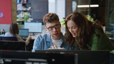 Neşeli ekip ofiste birlikte çalışıyor. Tablet bilgisayar ekranını yakından inceliyorlar. Mutlu gülümseyen meslektaşlar zafer kazandıkları için heyecanlı hissediyorlar. Gülen iş çifti beşlik çakıyor.