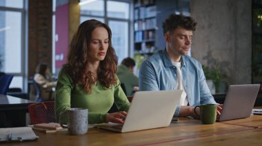 İki çalışan çalışma odası yaratıcı işyeri yakın çekim. Birlikte iş projesi planlayan dizüstü bilgisayarlar yazan birkaç ciddi yönetici. Odaklanmış takım profesyonel şirket çalışanları iş akışıyla meşgul