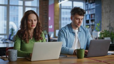 Ofiste çalışan olumlu yöneticiler, yaratıcı iş yerlerini kapatıyorlar. Birlikte iş projesi planlayan dizüstü bilgisayar yazan gülümseyen bir çift. Mutlu erkek kadın profesyonel kamera portresi