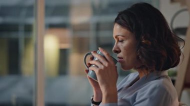 Karanlık ofiste kahve içen kadın yönetmen rahat görünüyor. İşyerinde geç saatlere kadar çalışmaya ara veren başarılı bir iş kadını. Şirket yöneticisi işten sonra dinlenme anının tadını çıkarıyor.