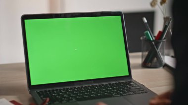 Çalışan, uzaktaki iş yerinde yeşil ekran laptopunu izliyor. Ofisteki klavye modelleme bilgisayarında tanınmayan bir iş adamı tuşa basıyor. Masadaki Kromakey Dijital Alet 'te çalışan erkek eller