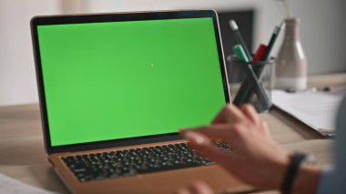 Şirketin iş yerinde yeşil ekran laptopunda sörf yapan bir kadın. İş kadını elleri dokunmatik kroma tuşlu bilgisayara dokunuyor. Bilinmeyen kadın çalışan web tarayıcı aygıtı çevrimiçi webinar izliyor.