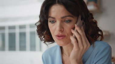 Ciddi bir ofis çalışanı şirket ofisindeki akıllı telefon görüşmesini kapatıyor. Endişeli iş kadını iş yerinde cep telefonuyla konuşuyor. İş yerinde konuşan bir kadın rapor veriyor..