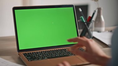 İş kadını, iş yerindeki yakın çekim için bilgisayarını uzaktan kumanda olarak kullanıyor. Ofisteki yeşil ekranlı dokunmatik bilgisayara dokunan tanınmayan kadın elleri. Kadın serbest çalışan krom anahtar aygıtını tarıyor.