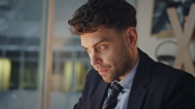 Akşamki iş yerinde düşünceli lider planlama projesi. Ciddi bir iş adamı akşam ofiste iş hakkında kafa yoruyor. Tıraşsız şirket çalışanı karanlık çalışma alanında tek başına oturmayı düşünüyor..