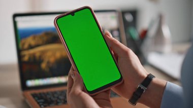 Şirketin iş yerinde krom anahtarlı cep telefonu tutan bayan patron. Ofisinde yeşil ekranlı cep telefonu olan tanınmamış iş kadını elleri. Profesyonel yönetici akıllı telefon uygulamasına göz atıyor
