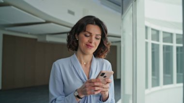 Akıllı telefondan mesaj atan pozitif ofis çalışanı şirket koridorunu kapatıyor. Zarif bir iş kadını cep telefonuna mesaj yolluyor panoramik pencereye doğru gidiyor. Kendine güveni tam bir patron. Çalışmak için acele eden bir uygulama..