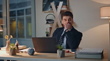 Rahatlamış yönetici laptopun çalışma masasında kahve içiyor. Ciddi profesyonel işçiler sıcak içeceklerden hoşlanırlar. Akşam ofis sandalyesinde otururlar. Düşünceli bir çalışan iş stratejisi üzerine kafa yoruyor..