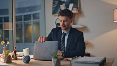 Geç dönem çalışanları dizüstü bilgisayarın kapağını kapatıyorlar. Ofiste tatmin olma projesini kapatıyorlar. Başarılı yönetici rahat koltukta rahatlarken gülümsüyor. Mutlu iş adamı karanlık ve modern işyerinde işini akşam bitirir..