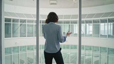 Modern ofis koridorunda cep telefonu tartışan hareketli bir kadın. Pencere kenarındaki telefon konuşmasından şikayet eden sinirli bir kadın yönetici. İş kadını cep telefonu konuşmasından memnun değil