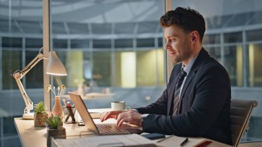 Gülümseyen menajer dizüstü bilgisayardaki işini akşam modern ofis kapanışında bitirir. Tatmin olmuş iş adamı masa başı işyerindeki bilgisayar kapağını kapatıyor. Mutlu bir çalışan kariyer terfisini düşünürken kendini başarılı hissediyor