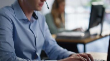 Operatör elleri klavye işleme istemcisi talebini birlikte çalışma ofisine yakın çekimde yazıyor. Kulaklık danışmanlığında çalışan ekip çalışanları profesyonel hizmet sunan müşteriler. Çağrı Merkezi takım çalışması kavramı