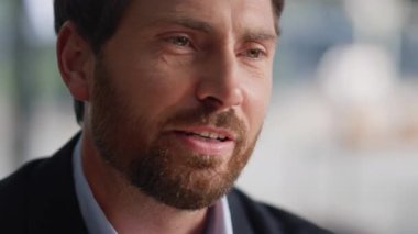 Yakın plan sakallı adam şehir kafesinde oturan bilinmeyen bir arkadaşla konuşuyor. Portre özgüvenli iş adamı resmi takım elbise giyiyor ve Interlocutor ile iletişim kuruyor. Sakin adam kafeteryada dostça sohbetin keyfini çıkar..