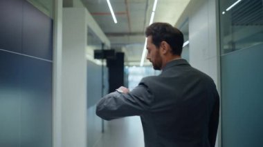 Resmi takım elbise direktörü arka pencereyi boş bırakıyor. Sakallı, profesyonel iş yeri inşaatına adım atan meslektaşlarını yakından selamlıyor. Rahat adam saate bakıyor.