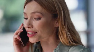 Kapalı bir iş kadını cep telefonundan konuşuyor. Pencerenin yanında oturup iş hakkında konuşuyor. Portre güzel sarışın kadın akıllı telefonu arıyor ve haberleri paylaşıyor. Ofiste konuşan zarif bayan danışman..