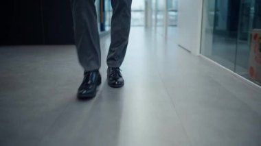 İş adamı bacakları ofis zemininde toplanıyor. Tanımlanamayan yönetmen gri girişte tek başına yürüyor. Başarılı bir profesyonel işçi zarif ayakkabılarla özel kabineye doğru yürüyor. 
