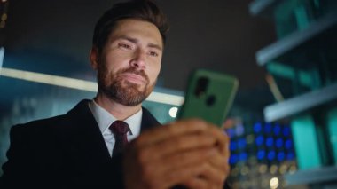 Şehir ışıklarında telefon mesajı okuyan gece işadamı portre çiziyor. Şen şakrak iş adamı akıllı telefon ekranına bakıyor akşam kasabasında tek başına başarıya seviniyor. Yakışıklı patron kendini başarılı hissediyor.