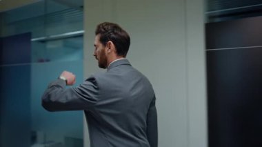 Gri ofis binasında modern cam salona gidiyor. Ciddi yönetmen el saatlerine bakar, zamanı kontrol eder. Sakallı işadamı, karşılama törenine katılıyor.