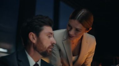 Kadın asistan, Odaklanmış Patron portresi için belge getiriyor. Gülümseyen bayan sekreter dizüstü bilgisayarla gece yarısı müdürüyle tartışıyor. Güvenilir iş çifti analiz raporu