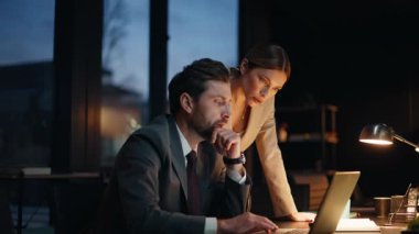 Modern ofiste bilgisayar ekranı arayan geç dönem iş arkadaşları. Gergin iş arkadaşları bu akşam bilgisayarı kapatamadılar. İş kadını destek ortağı. Şirket takımı kontrol raporu