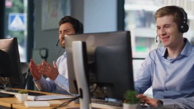 Servis masası personeli profesyonel müşteri desteği için kulaklıkla konuşuyor. Dost canlısı yardım ekibi müşterilere talimat vermekte yardımcı oluyor. Tele-pazarlama işçileri şirket ürünleri öneriyor.