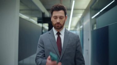 Şok olmuş finansör görünümlü cep telefonu boş koridora yaklaşıyor. Kötü haber okuyan stresli iş adamı koridorda başarısız oldu. Mad ceo kontrol hücre bildirimi duygularını gösterir